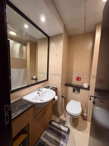a bathroom with a sink and a toilet and a mirror at Click Stay - JLT - Entire Studio & Balcony Lakes view Apartment -AM in Dubai