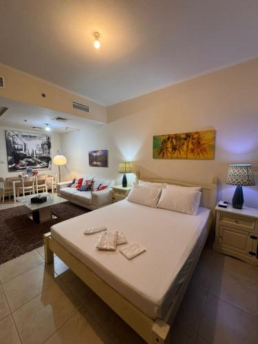 a bedroom with a large bed and a living room at Click Stay - JLT - Entire Studio & Balcony Lakes view Apartment -AM in Dubai
