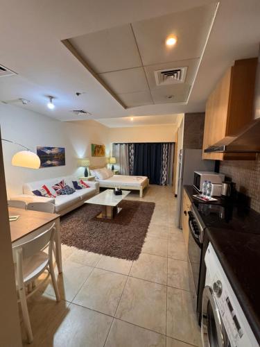 a kitchen and living room with a couch and a table at Click Stay - JLT - Entire Studio & Balcony Lakes view Apartment -AM in Dubai