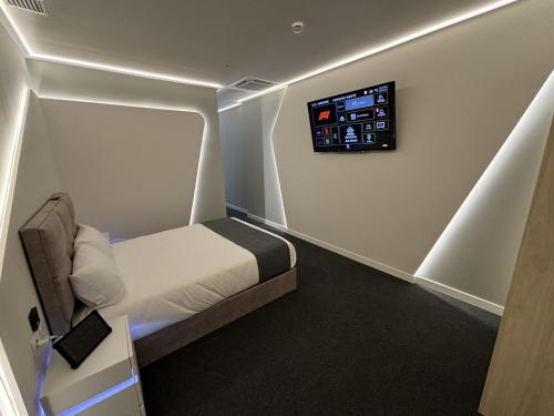 a small room with a bed and a tv on the wall at Futurotel Granada Dreams in Granada