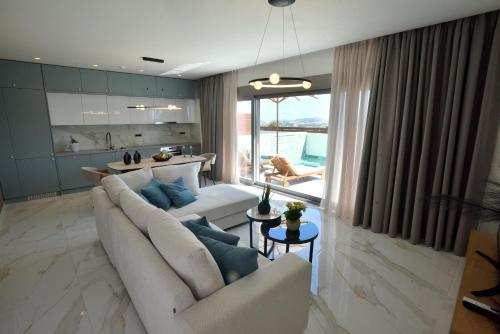 a living room with two white couches and a large window at Villa 101 Rhodes in Ixia