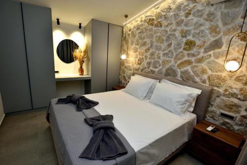 a bedroom with a bed with a stone wall at Villa 101 Rhodes in Ixia