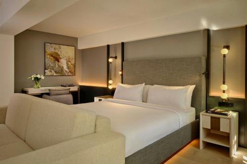 a hotel room with a bed and a couch at Ghent Marriott Hotel in Ghent