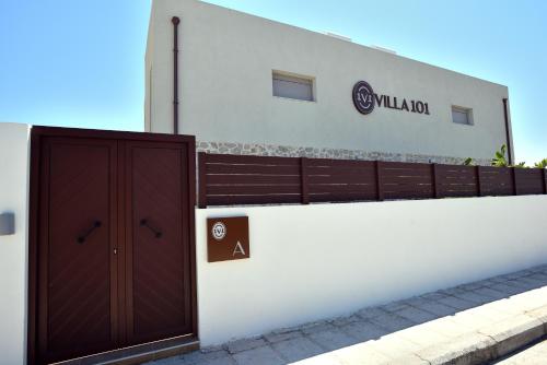 a building with a brown door on a white wall at Villa 101 Rhodes in Ixia