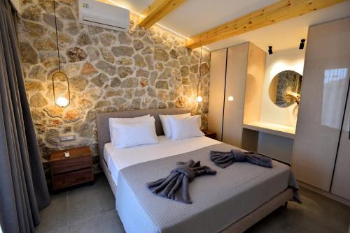 a bedroom with a bed and a stone wall at Villa 101 Rhodes in Ixia