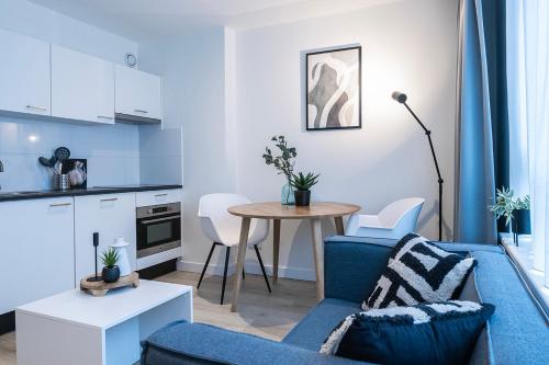 Una sala de estar con un sofá azul y una mesa. en Fresh And Equipped Apartment Near Hotspots, en Eindhoven