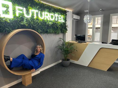 a woman is sitting in a circular room in an office at Futurotel Granada Dreams in Granada