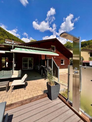 a wooden deck with a bench and a house at Swiss Escape, Chalet with Private Spa & Easy Train Access in Frinvillier