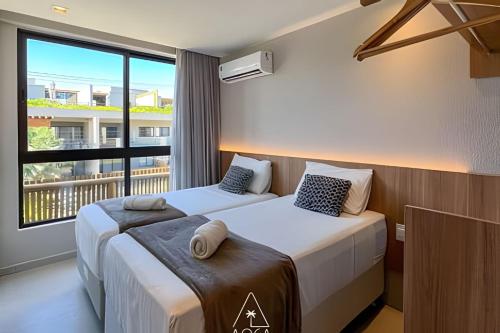 2 Betten in einem Hotelzimmer mit Balkon in der Unterkunft Villa Kanui a 100 metros da Praia de Tatuamunha in Tatuamunha
