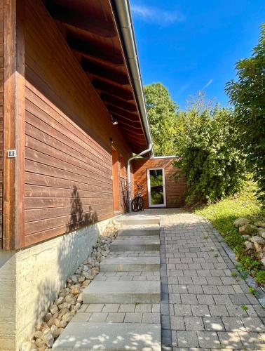 a brick walkway leading to a building at Swiss Escape, Chalet with Private Spa & Easy Train Access in Frinvillier