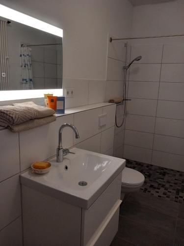 a bathroom with a sink and a toilet and a mirror at K9 Wohnungen in Münster