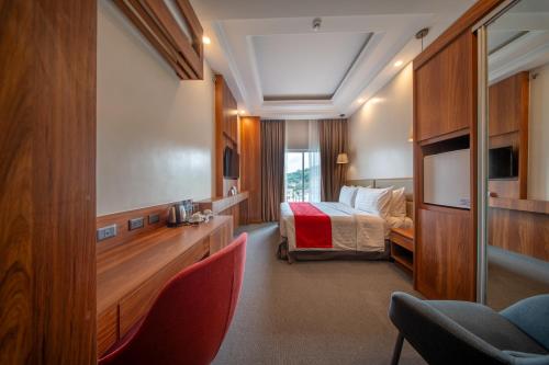 a hotel room with a bed and a desk and chairs at Best Western Plus Hotel Subic in Olongapo