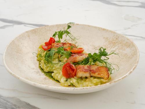 a bowl of food with shrimp on top of risotto at Aegean Melathron Thalasso Spa Hotel in Kallithea Halkidikis