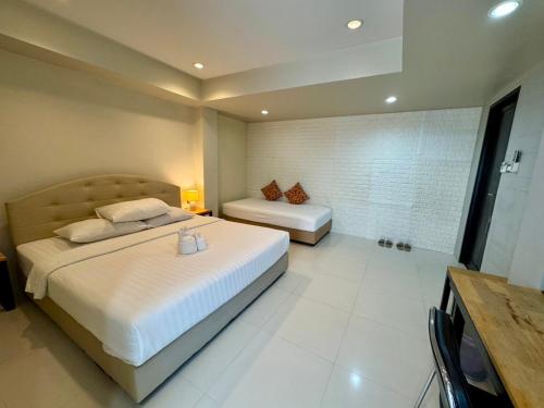 a hotel room with two beds and a television at Le Neuf Nakorn Lampang in Lampang