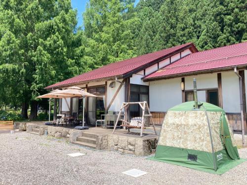 a house with a green tent in front of it at GuestHouse HESTA Itadorigawa Onsen - Vacation STAY 89862v in Gujo