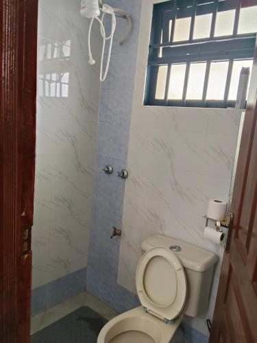 a bathroom with a white toilet and a window at 3 Bedroom with SQ Simba in Naivasha