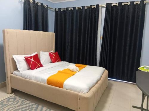 a bed with red and orange pillows in a room at 3 Bedroom with SQ Simba in Naivasha