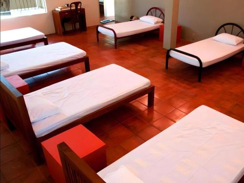 a room with four beds and a wooden floor at Vanaro Resort in Yala