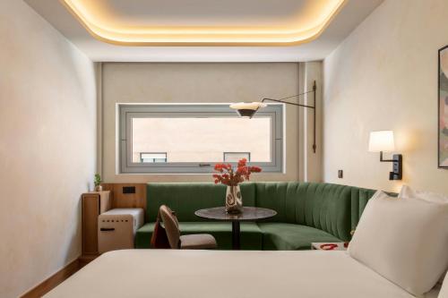 a living room with a green couch and a table at Salitre Hotel, Sonder by Marriott Bonvoy in Málaga