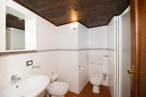 a bathroom with a white sink and a toilet at Tenuta La Selva Casa Pendio in Casal Velino