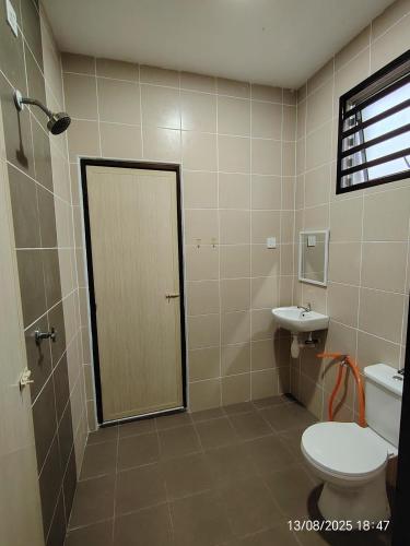 a bathroom with a toilet and a sink at Teratak Asyakira in Bedung