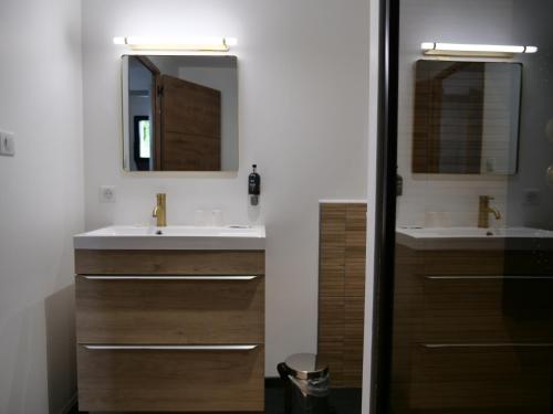 a bathroom with two sinks and two mirrors at Hotel de la Gare in Saint-Mihiel