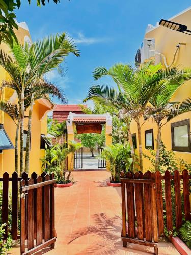 a courtyard of a house with palm trees and a gate at Laa House in Hoi An