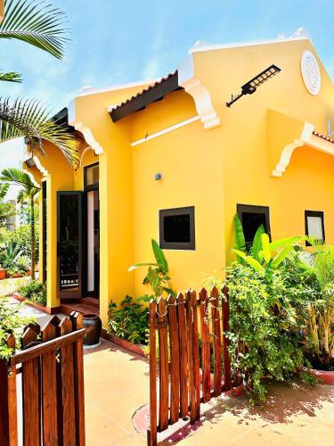 a yellow house with a fence in front of it at Laa House in Hoi An