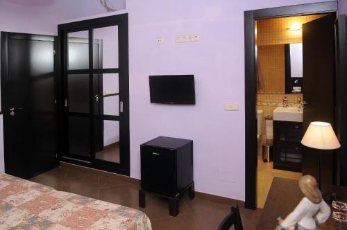 a room with a bed and a television on the wall at La Estancia del Rincon in Cabo de Palos