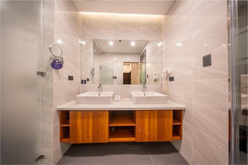a bathroom with two sinks and a mirror at Best Western Plus Hotel Subic in Olongapo