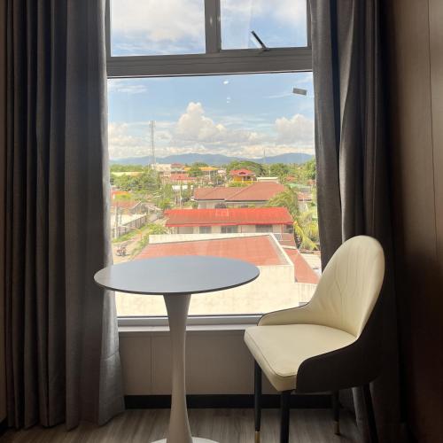 a table and chair in front of a window at Sky Vista Hotel in San Jose