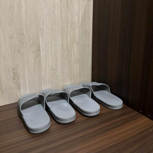 four pairs of slippers sitting on a wooden floor at Sky Vista Hotel in San Jose
