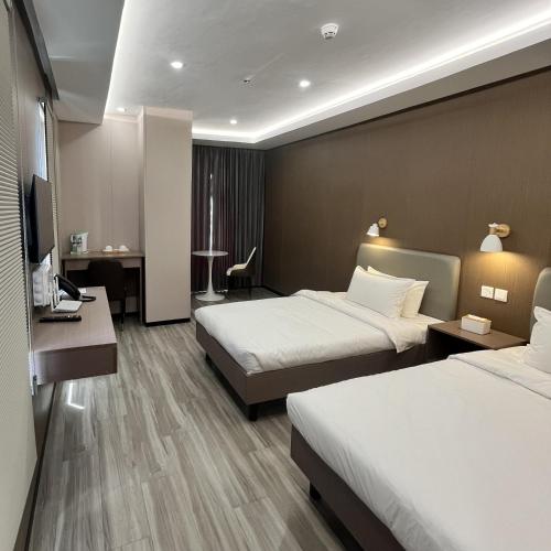 a hotel room with two beds and a desk at Sky Vista Hotel in San Jose