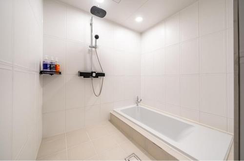 a white bathroom with a tub and a shower at Pocheon Sky Drive In Hotel in Pocheon