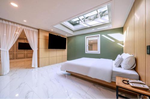 a bedroom with a large white bed and a skylight at Pocheon Sky Drive In Hotel in Pocheon