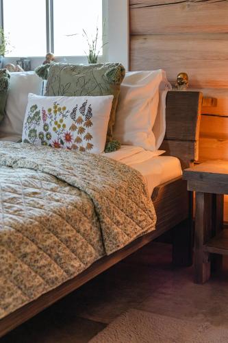 a bedroom with a bed with pillows and a table at CHATA POD PRZEHYBĄ in Stary Sącz