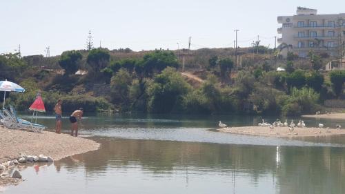 a group of people standing on the shore of a river at 2F Saranda Apartment 3 in Sarandë