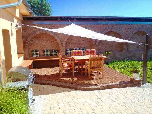 a wooden deck with a table and chairs under a white tent at Vila BOHI in Lednice