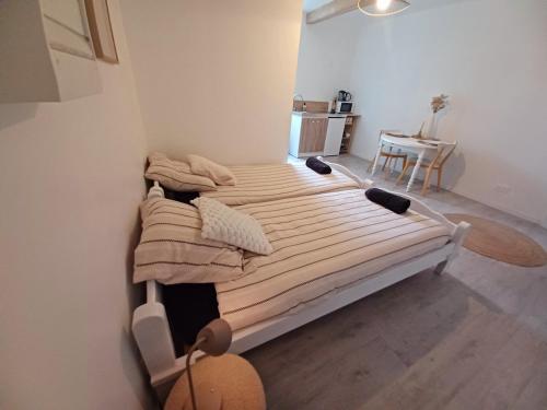 two beds in a small room with a table at Studio Garrevaques Calme et Charme à la Campagne - Lauren in Garrevaques