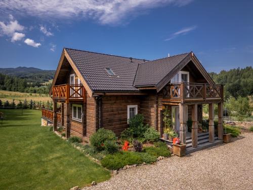 a log cabin with a gambrel roof at CHATA POD PRZEHYBĄ in Stary Sącz