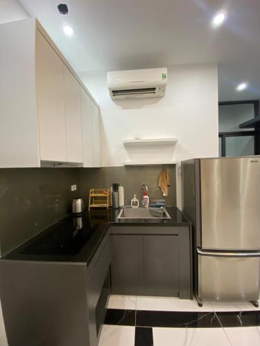 a kitchen with white cabinets and a stainless steel refrigerator at Luxury Apartment with City View Quang Trung Hadong in Hà Ðông