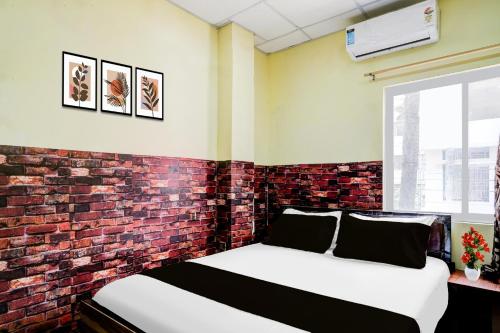 a bed in a room with a brick wall at Collection O Ganeshguri Nayanpur Formerly Rainbow Residency in Guwahati