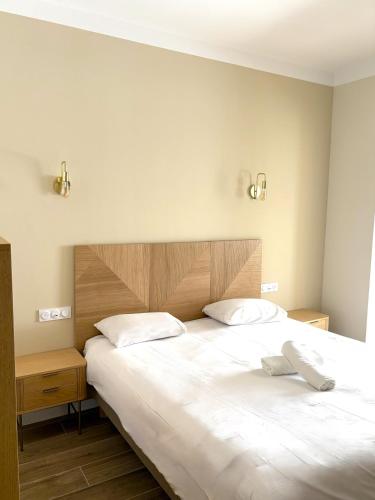 a bedroom with a large bed with two white pillows at Adonis Sanary Grand Hôtel des Bains in Sanary-sur-Mer