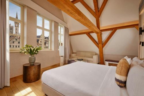 a bedroom with a white bed and two windows at Ghent Marriott Hotel in Ghent
