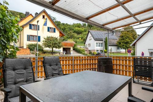 a patio with a table and chairs on a fence at Ferienhaus Rebsteige in Ihringen