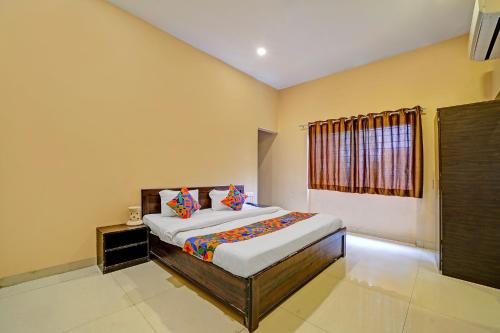 a bedroom with a bed and a window at FabHotel Grand Stay Ambedkar Nagar in Indore