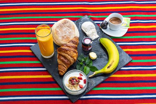 a tray with a breakfast of bread and a banana and coffee at Living Funchal Executive in Funchal