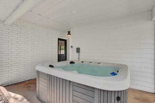 a large bath tub in a white room at Wanderlust #4 | Hot Tub | Shared Outdoor Space in Fredericksburg