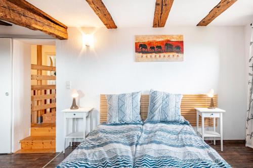 a bedroom with a bed and two white tables at Ferienhaus Rebsteige in Ihringen