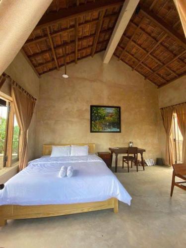 a bedroom with a bed with two white towels on it at HappyZen Farm in Vung Tau